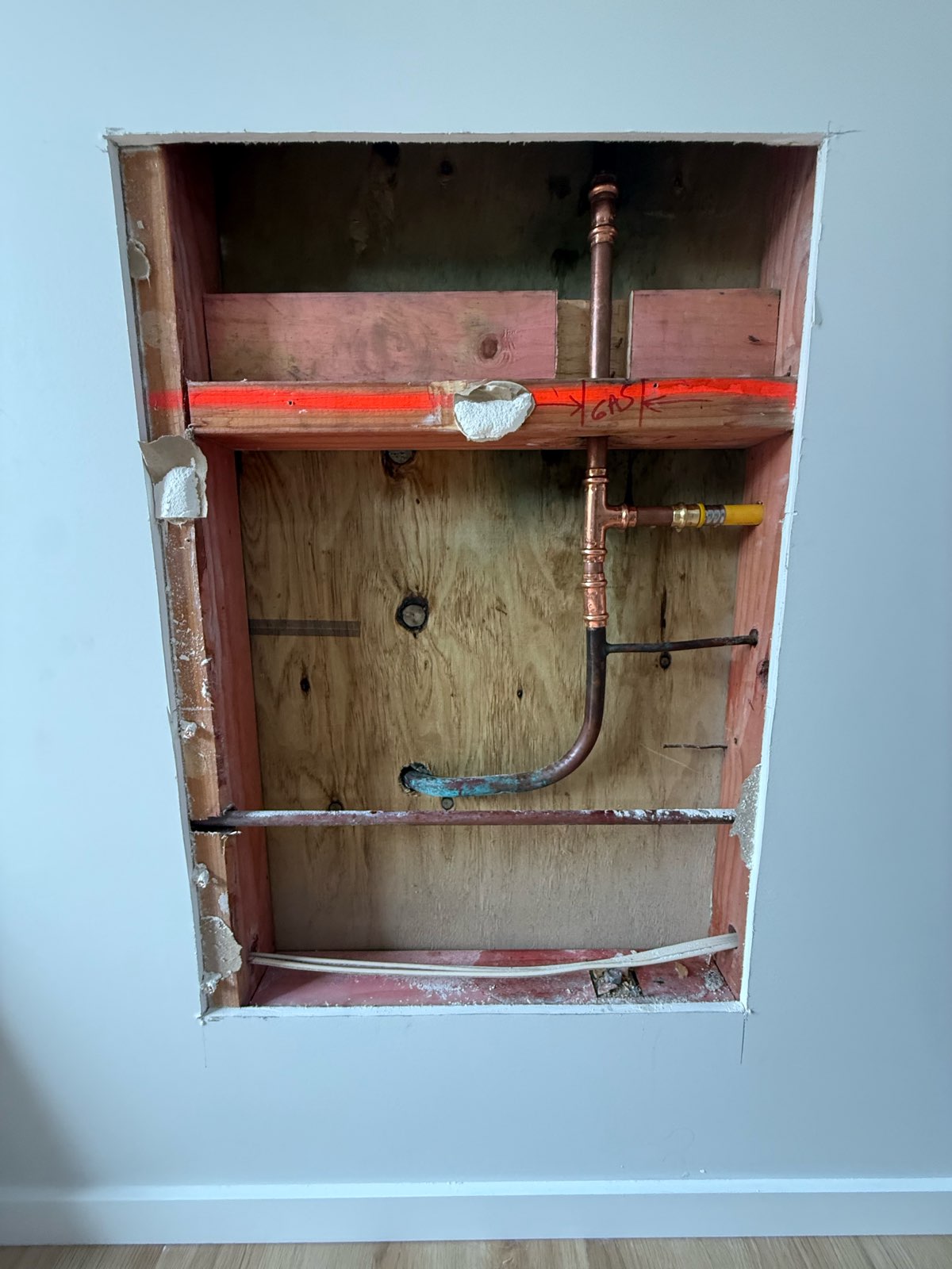 Wall opened up showing new copper gas pipe section installed to replace faulty transition fitting in St Heliers home