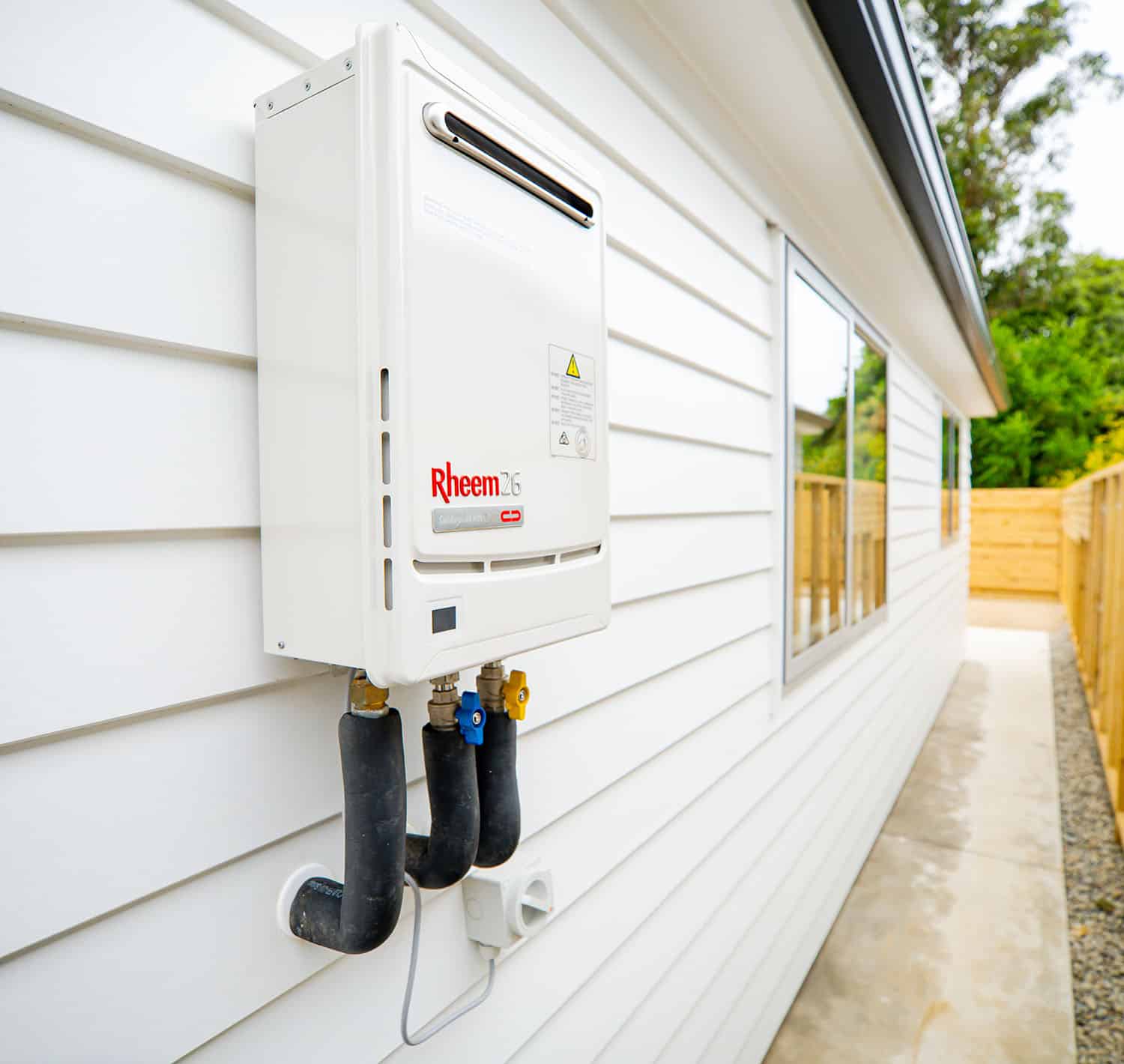 Rheem 26 continuous flow hot water unit installed on exterior wall by Water & Gas Worx